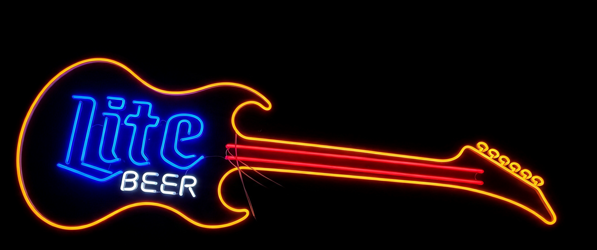 Neon guitar sign displaying Lite Beer in blue and orange tubing, against a dark background.