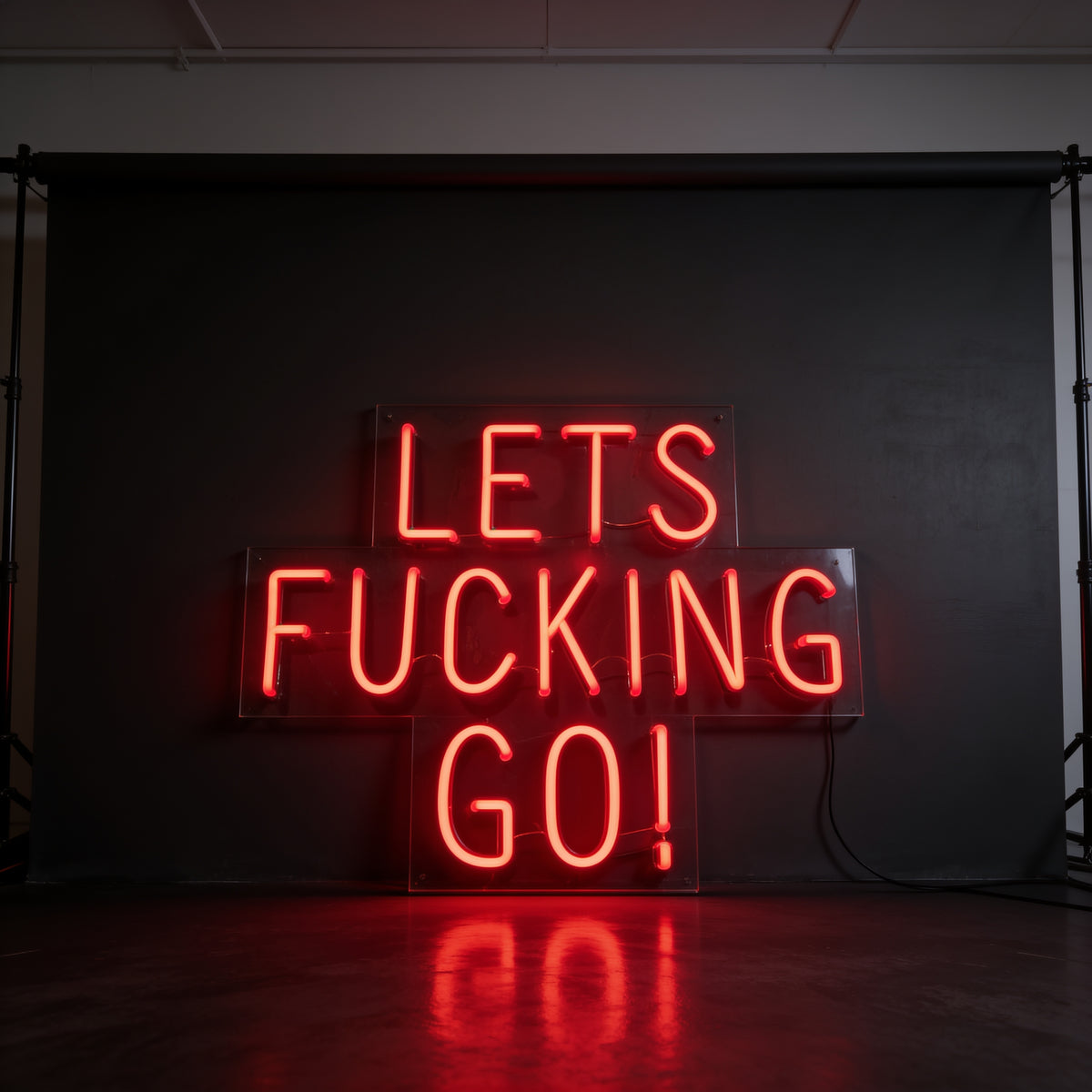 Red neon sign reading “Let’s fucking go!” on a dark background.