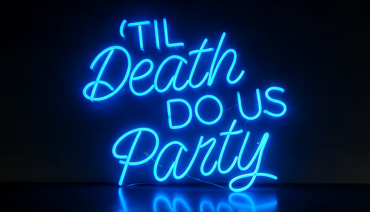 Blue neon sign reading “’Til Death Do Us Party,” in mixed cursive and block lettering on a dark background.